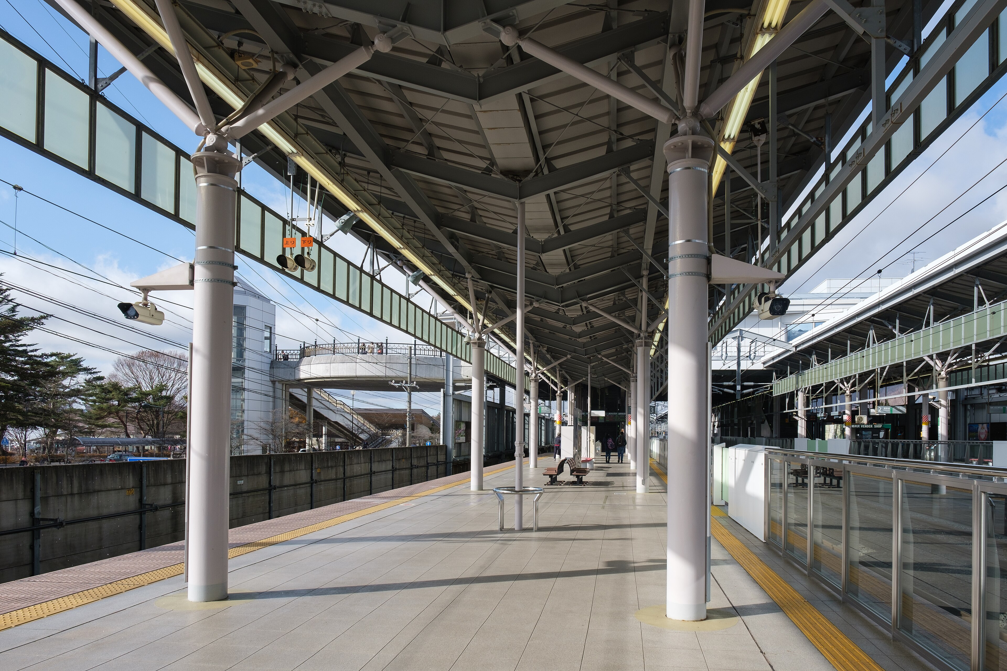 The Shinkansen platform at Karuizawa Station under a wide steel canopy