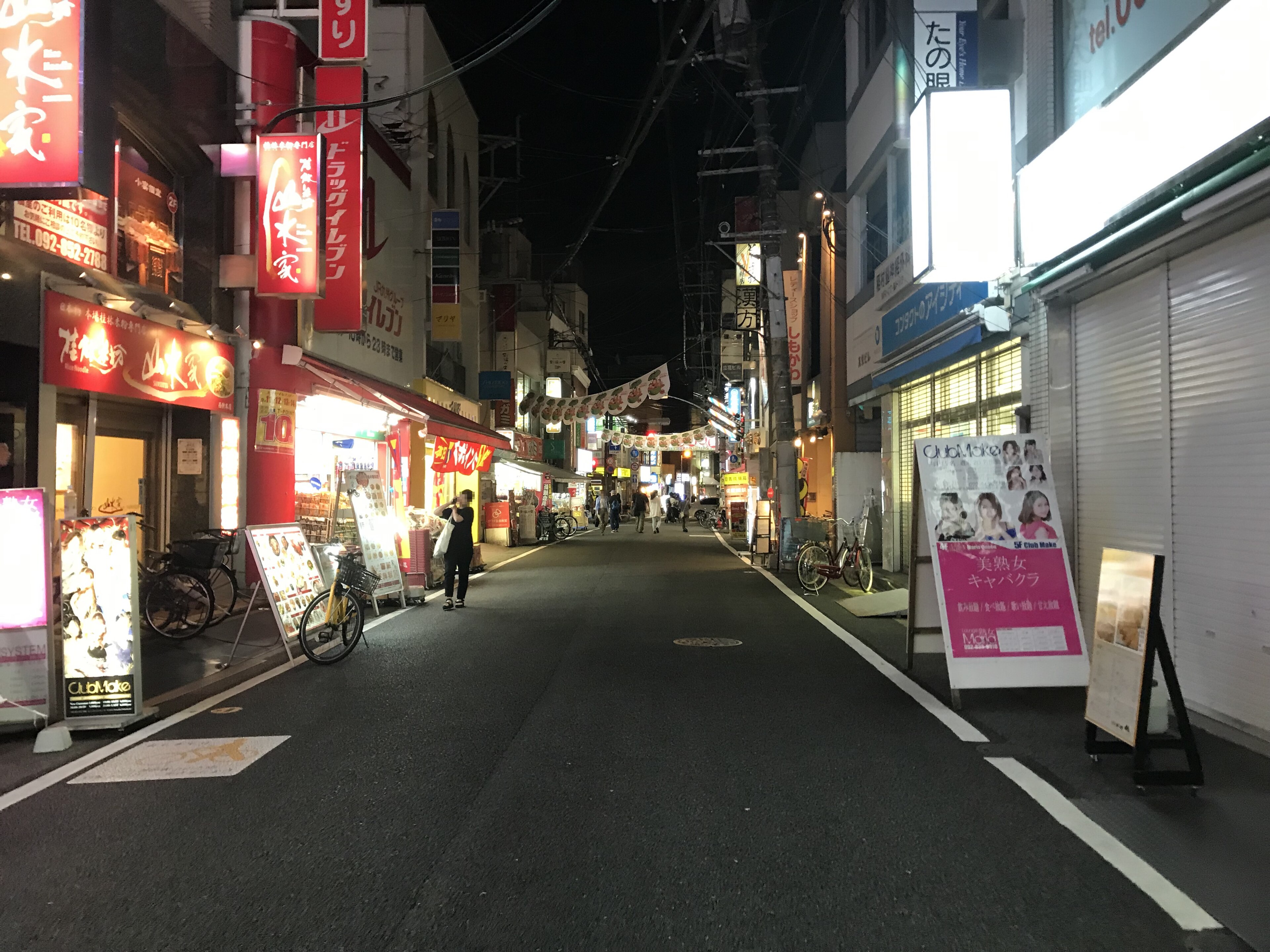 Nishijin Central shopping street in Fukuoka at night, lit shop signs on both sides