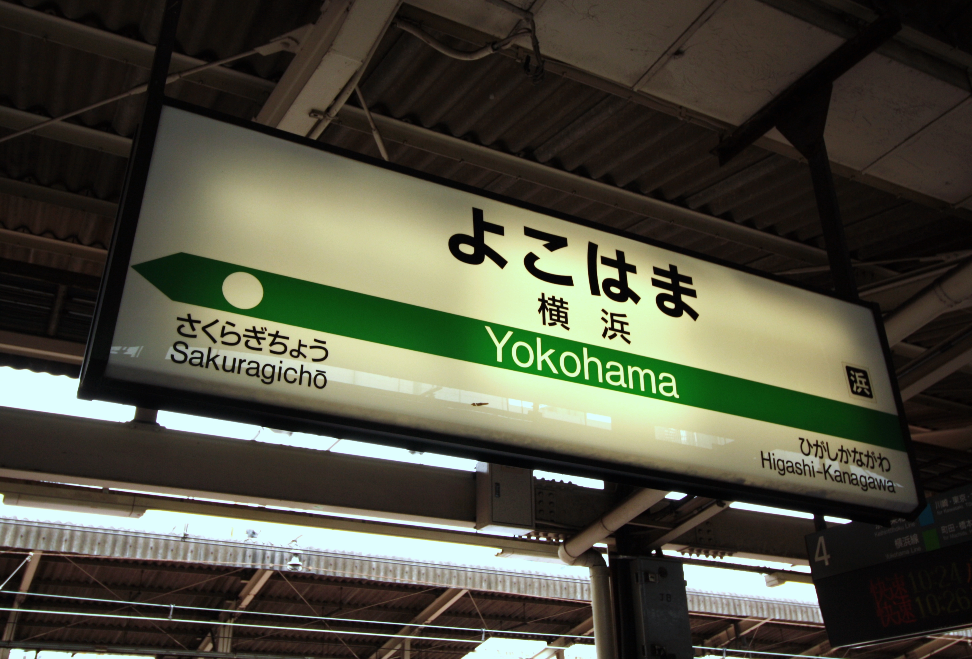 A JR station name sign for Yokohama hanging above the platform