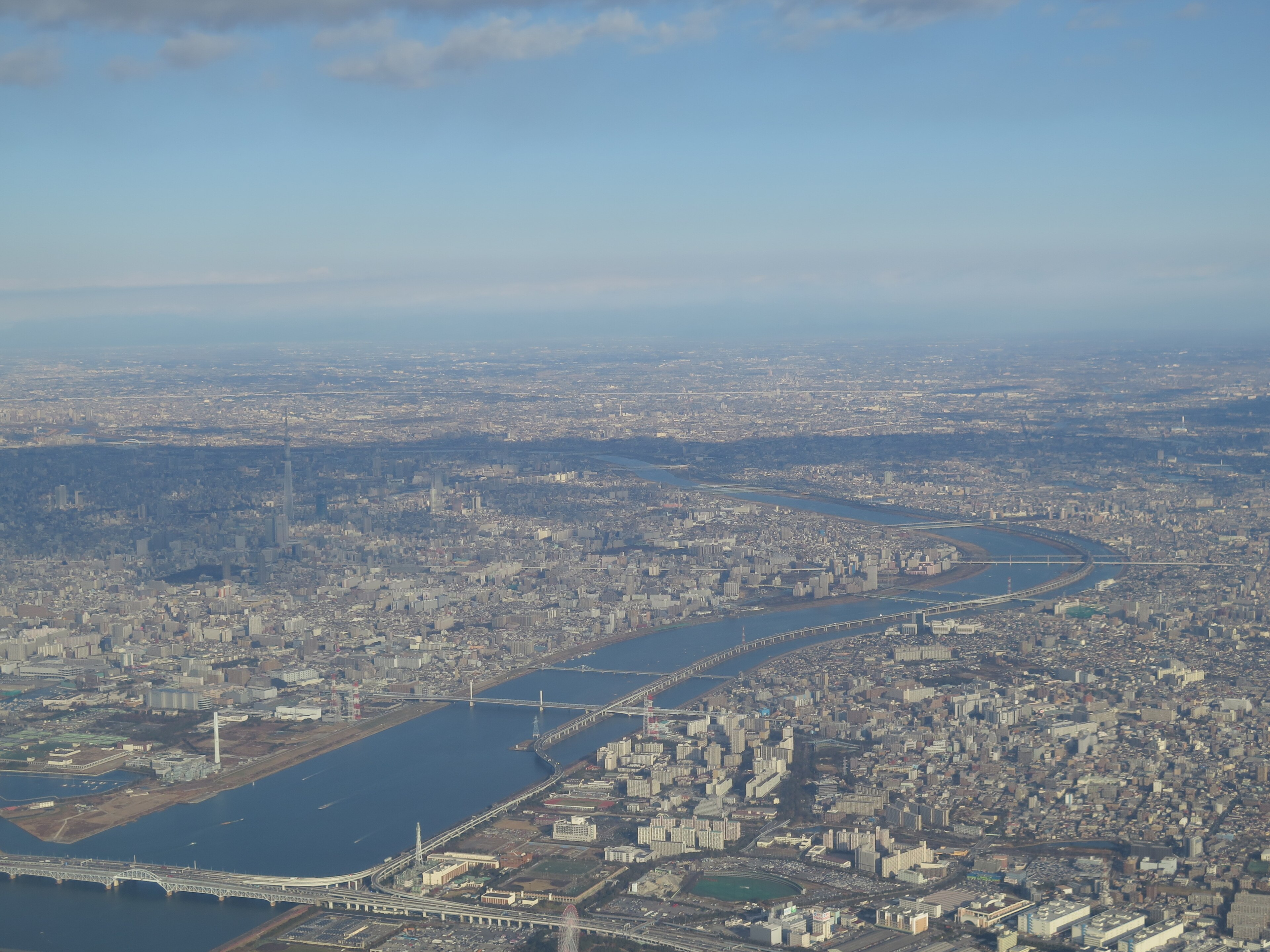 Tokyo seen from an airplane, the Sumida river and Skytree among dense city blocks