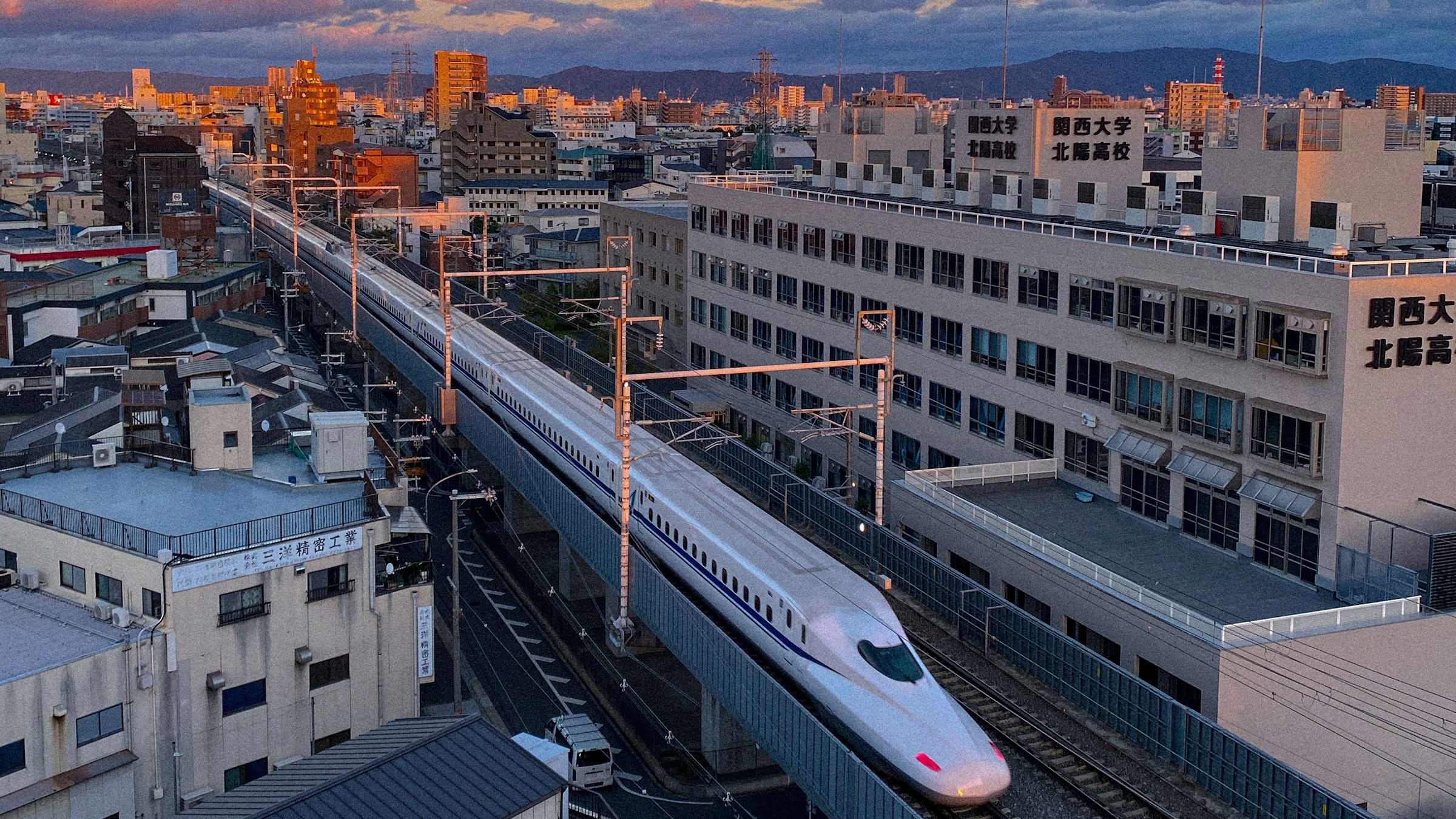 A Shinkansen running past high-rise buildings in Osaka